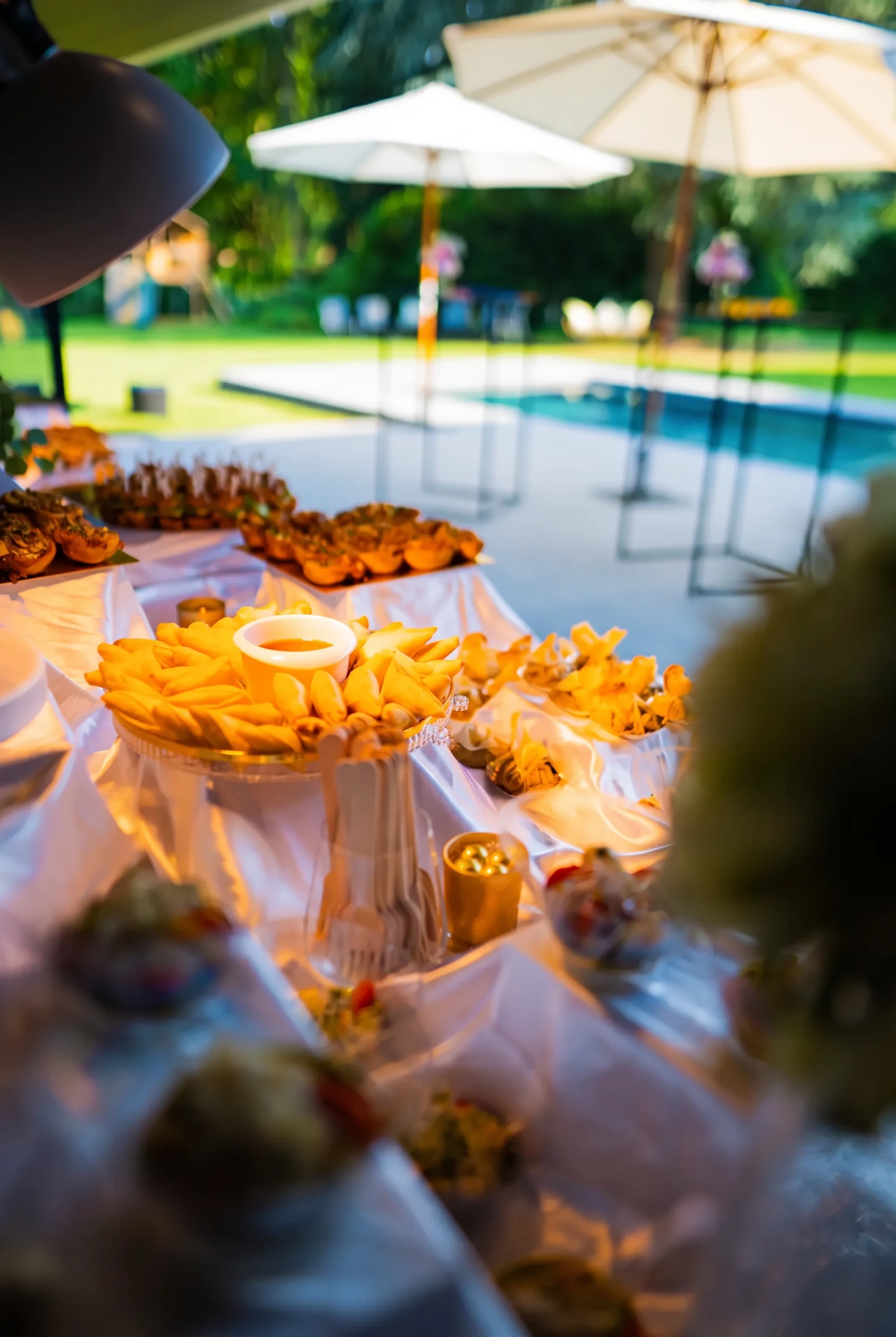 Buffet buiten bij een zwembad en een tuin.