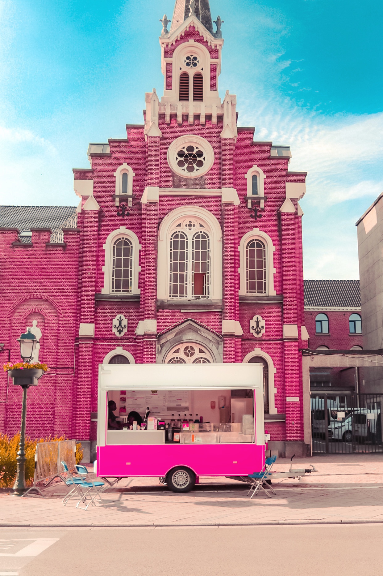 Le foodtruck rose Deby's Delice installé devant une église en briques roses